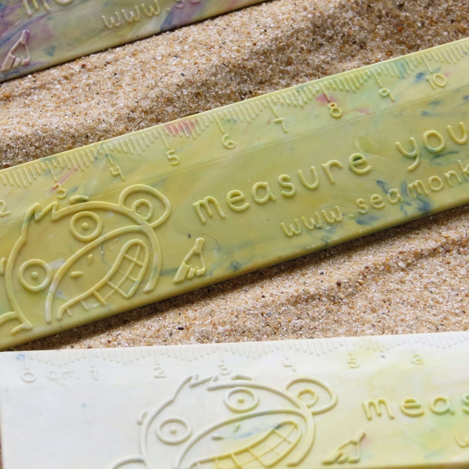 Eco-friendly monkey-themed ruler on sand, showcasing sustainable design and playful creativity.